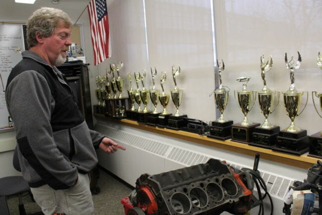 Juneau-Douglas High School automotive instructor Steve Squires points out some of the awards students have won over the years for technical knowledge. (Photo by Adelyn Baxter/KTOO)