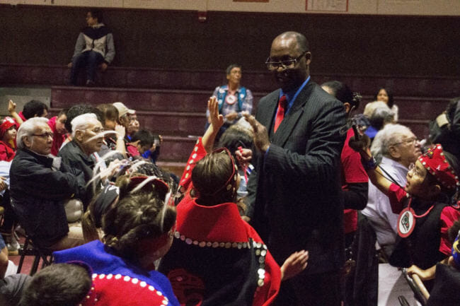 A student gives a high five to Hoonah Schools superintendant Ralph Watkins during 28th annual Heritage Celebration Ku.éex' in Hoonah, Alaska. (Photo by Tripp J Crouse/KTOO)