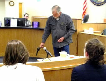 Chad Kendrick demonstrates the use of .45 single-action revolver in Juneau Superior Court on May 4, 2018. Assistant District Attorney Amy Paige and Assistant Public Defender Deborah Macaulay watch in the foreground.