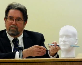 Dr. Todd Grey uses a Styrofoam model with knitting needles to demonstrate how two bullets may have passed through Tony Rosales. Grey testified May 7, 2018 during the Mark DeSimone homicide trial in Juneau Superior Court.