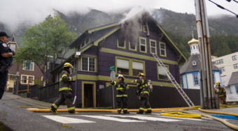 Firefighters work outside the house at the corner of Fifth and Franklin streets in Juneau after the fire there on May 28, 2018.