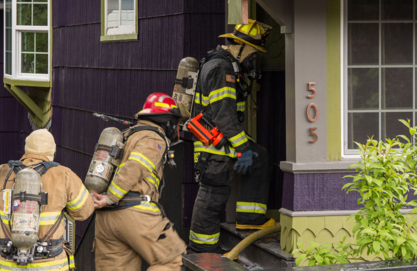 Firefighters enter the house at the corner of Fifth and Franklin streets in Juneau after the house fire there on May 28, 2018.