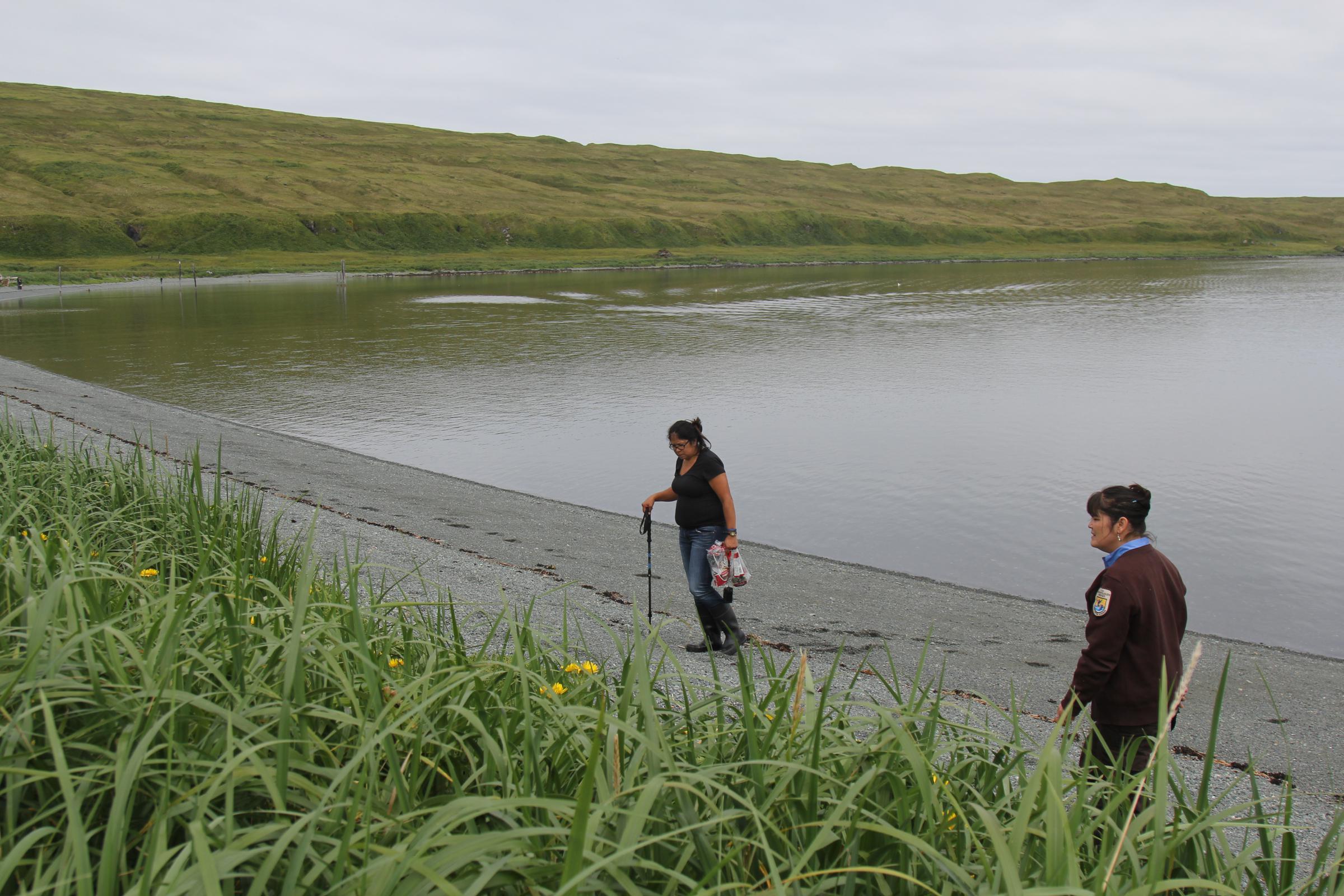 Theresa Deal, left, and Christine Kiehl peruse the beach for treasures to remember Attu. (Photo by Zoë Sobel/KUCB)