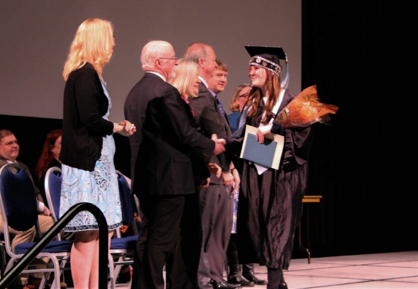 Yaaḵoosgé Daakahídi High School graduate Kiana Christopherson shakes the hand of district and school administrators after receiving her diploma on Sunday. (Photo by Adelyn Baxter/KTOO)