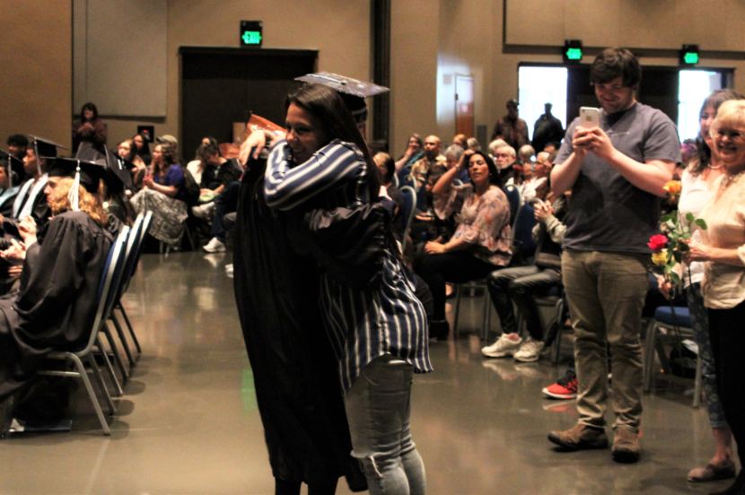 Kiana Christopherson hugs her sister Alicia Young after walking across the stage on Sunday. (Photo by Adelyn Baxter/KTOO)