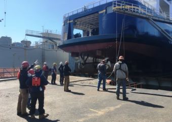 Vigor Alaska shipyard workers gather to watch the Tazlina get lowered into the water at the shipyard’s drydock in Ketchikan on May 16, 2018.