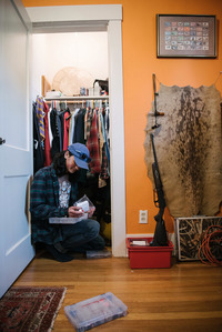 Sam Schimmel prepares fishing gear at his home. An accomplished fisherman and competitive shooter, he learned traditional Arctic subsistence hunting techniques from relatives in Alaska. (Photo by Kiliii Yuyan for NPR)