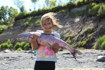A young fisher-woman displays a King caught on Kanakanak Beach in 2017. (Photo courtesy Sarah Grace Durrance)