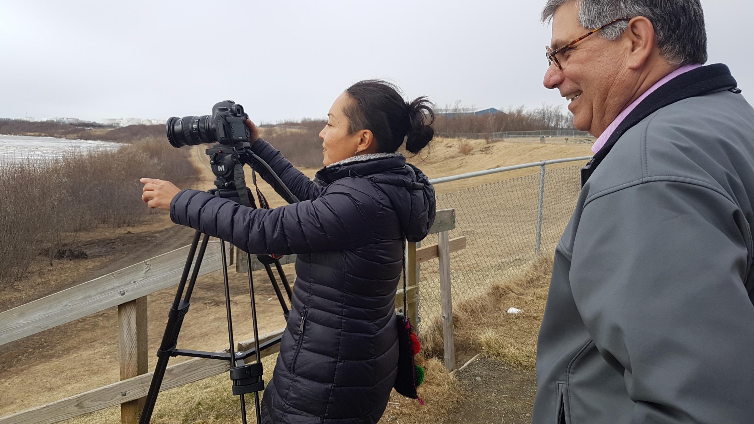Videographer Jacqueline Cleveland, left, films the Kuskokwim River on May 3, 2018, with Mark Trahant as they report on the Dental Health Aide Therapist Program in Bethel. (Photo by Christine Trudeau/KYUK)