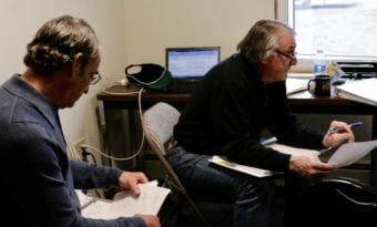 Bethel City Manager Peter Williams, left, and then-Finance Director Jim Chevigny review the FY 2018 budget at Bethel City Hall on June 8, 2017. Chevigny resigned Wednesday, June 27, 2018. (Photo by Christine Trudeau/KYUK)