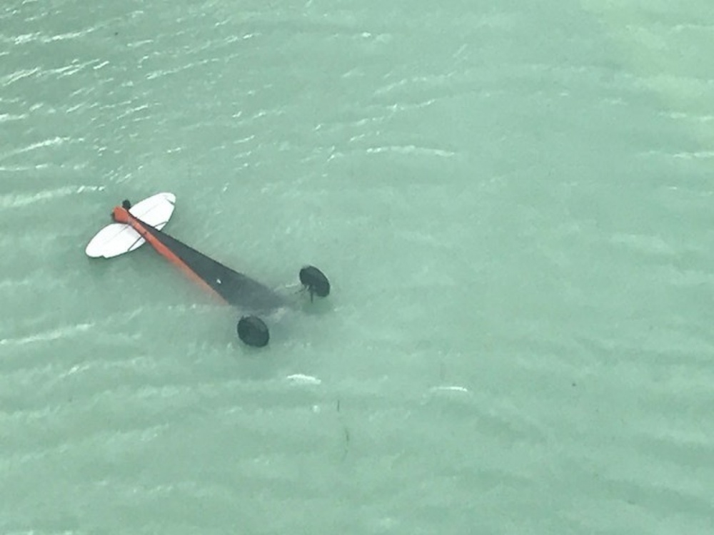 A Coast Guard Air Station Sitka helicopter aircrew locates a downed and inverted aircraft in Crillon Lake, in Glacier Bay National Park, Alaska, July 18, 2018. (Photo courtesy Coast Guard)