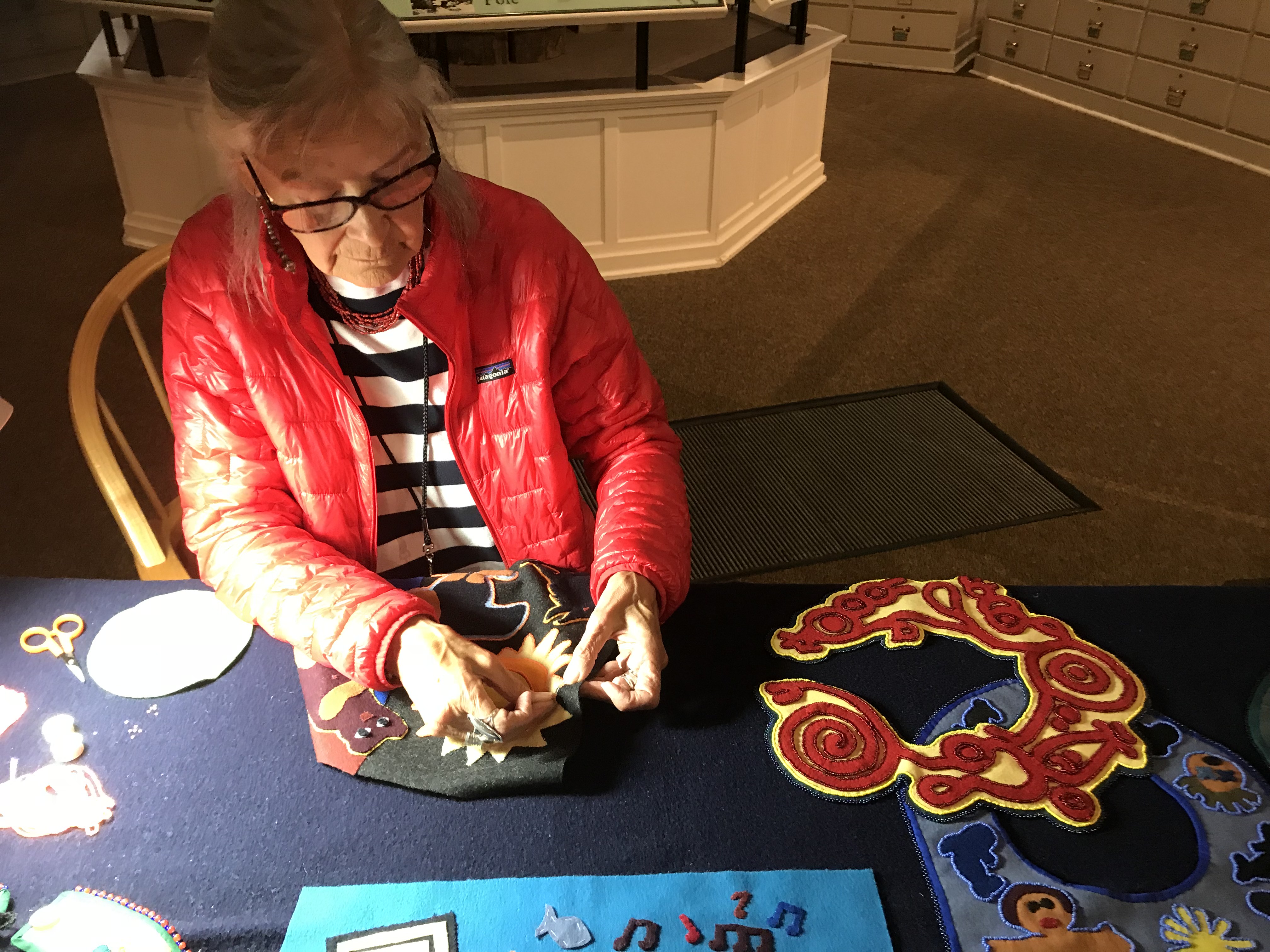 Chloe French adds beads to her felt bib. (Photo by Rachel Cassandra/KCAW)