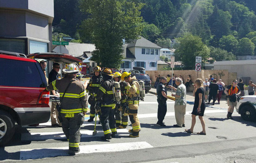Firefighters and residents outside Mendenhall Tower Apartments the morning of July 5, 2018, after some residents were evacuated after a fire. (Photo by Tripp J Crouse/KTOO)