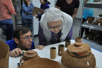 Hans Chester, left, of Sealaska Heritage Institute, and master Haida weaver Delores Churchill examine spruce root basketry in the collections vault of the Father Andrew P. Kashevaroff State Library, Archives and Museum in August 2017. (Photo by Davina Cole, courtesy Sealaska Heritage Institute)