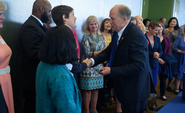 Rep. Ivy Spohnholz and Gov. Bill Walker shake hands after he signed of Senate Bill 105 into law during an Anchorage Chamber of Commerce luncheon at the Dena'ina Center in Anchorage on Aug. 6, 2018. Spohnholz sponsored a health care price transparency bill that was folded into SB105. It promotes competition for health care services by requiring providers to post prices for their most common health care services.