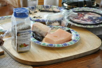Kunniak’s original Salt and Spice mixture next to a plate of bowhead whale. She now carries 11 different flavors, including “Black Lava” and “Ghost Blend.” (Photo by Erin McKinstry/Alaska Public Media)