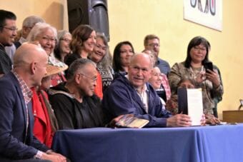 Gov. Bill Walker holds up the signed Administrative Order 300 surrounded by Alaska Native language advocates. (Photo Adelyn Baxter/KTOO)
