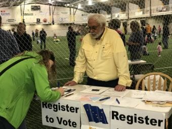 AEYC Board member Dave Newton registers a voter at an event in August. (Photo courtesy of AEYC)