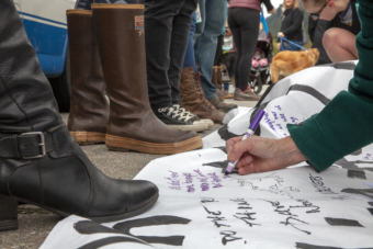 Dozens signed a banner outside of U.S. Sen. Lisa Murkowski's office during rally against U.S. Supreme Court nominee Brett Kavanaugh on Friday in Juneau.