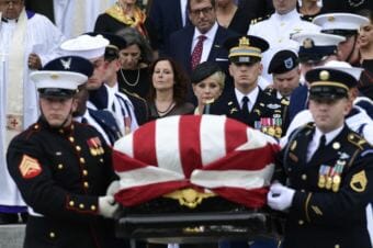 The casket of Sen. John McCain, R-Arizona., is carried out of the Washington National Cathedral in Washington, Saturday, Sept. 1, 2018, after a memorial service, as Cindy McCain is escorted by her son Jimmy McCain and other family members.
