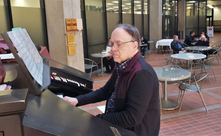 J. Allan MacKinnon plays Kimball organ in the atrium of the State Office Building in Juneau on Friday, Oct. 26, 2018. He's one of a handful of organ players in town who regularly play Friday lunchtime concerts on it.