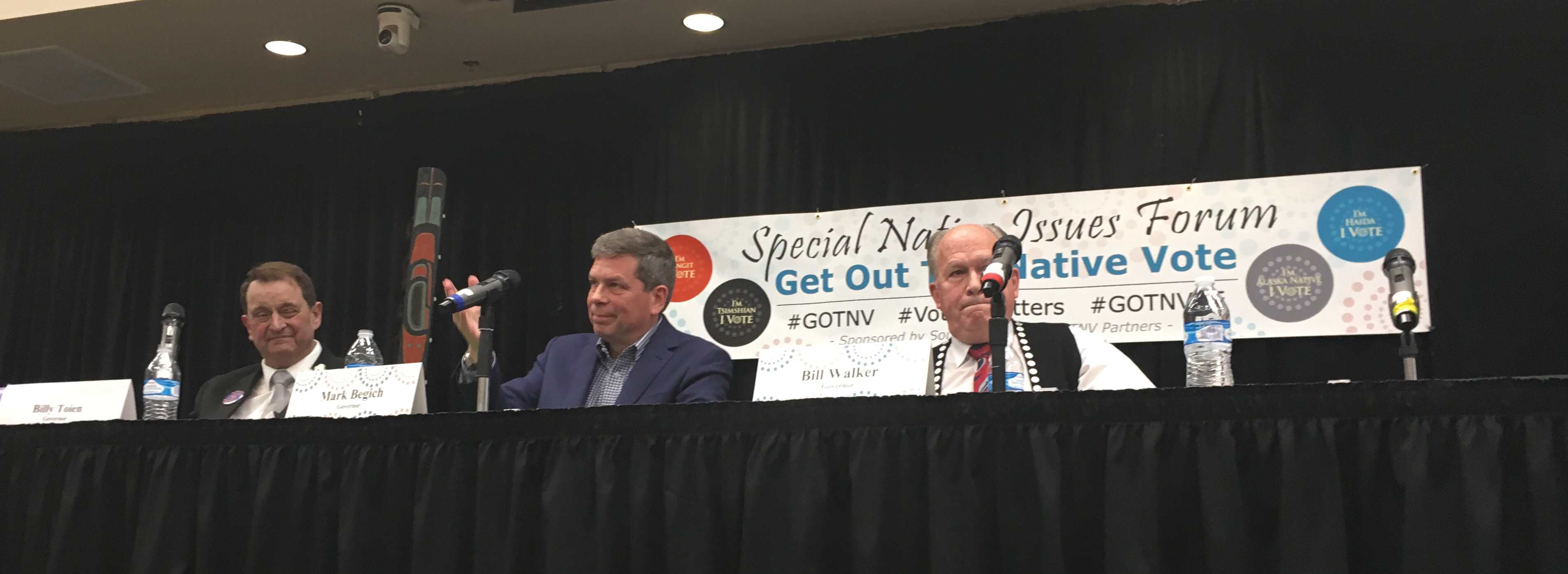 Libertarian Billy Toien, Democrat Mark Begich and independent Gov. Bill Walker receive audience applause at the end of the Get Out the Native Vote candidate forum, Oct. 2, 2018, in Juneau. The microphone on the right is for Republican Mike Dunleavy, who didn't attend. (Photo by Andrew Kitchenman/KTOO and Alaska Public Media)