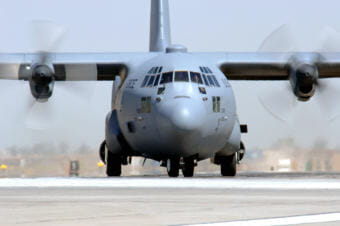 A C-130 Hercules taxis on a runway.