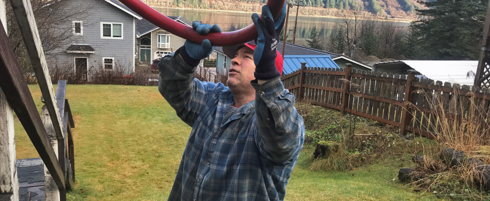 Phil Isaak, of Ike's Fuel finishes topping off a heating oil tank on November 15, 2018, in Juneau, Alaska. Isaak says costs in Alaska don't really match up well with heating fuel costs in the rest of the country. (Photo by Rashah McChesney/Alaska's Energy Desk)