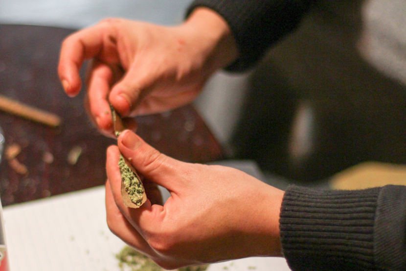 Man rolling marijuana joint.