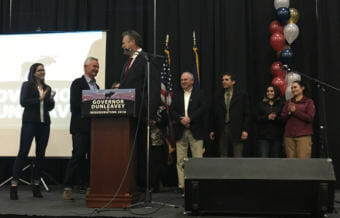 Gov. Mike Dunleavy (center) was surrounded by his family at his inaugural celebration at the Menard Sports Center in Wasilla. From left: his daughter Ceil Ann; his brother Francis, of Houston, Texas, and Salt Lake City, Utah; Mike Dunleavy; his brother William, of Allentown, Pennsylvania; his brother Patrick of Scranton, Pennsylvania; his daughter Catherine; and his daughter Maggie. His wife Rose is obscured in the photo. Dec. 4, 2018. (Photo by Andrew Kitchenman/KTOO and Alaska Public Media)