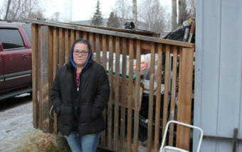 Jessica Fox stands outside her home, which was badly damaged by the Nov. 30 earthquake. Fox said her porch was level before the earthquake hit.