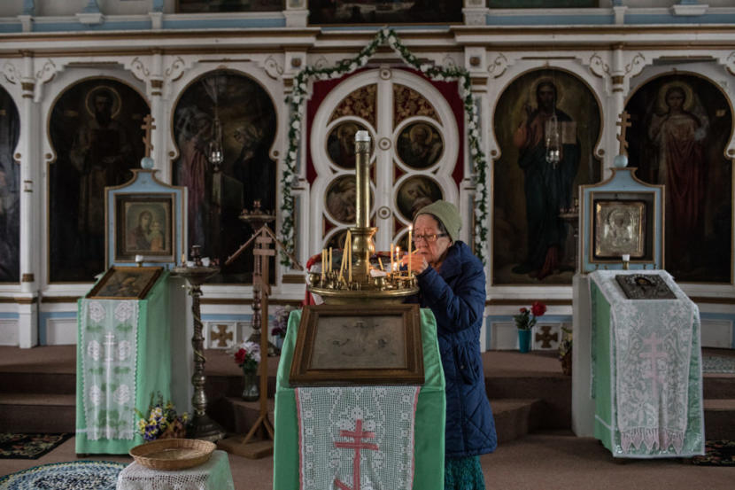 Irene Christiansen, 83, lights candles in the Russian Orthodox church in King Cove, Alaska. A respected elder and one of only two in King Cove who speak Aleut, Christiansen is among the few in the town who speaks against the planned road through the wildlife refuge.