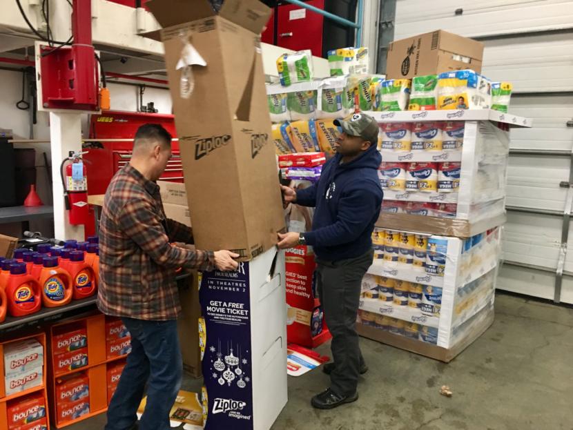 Quy Nguyen (left) and Mahire A'Giza unpack donations at the consumables pantry on Jan. 22, 2019. (Photo by Zoe Grueskin/KTOO)