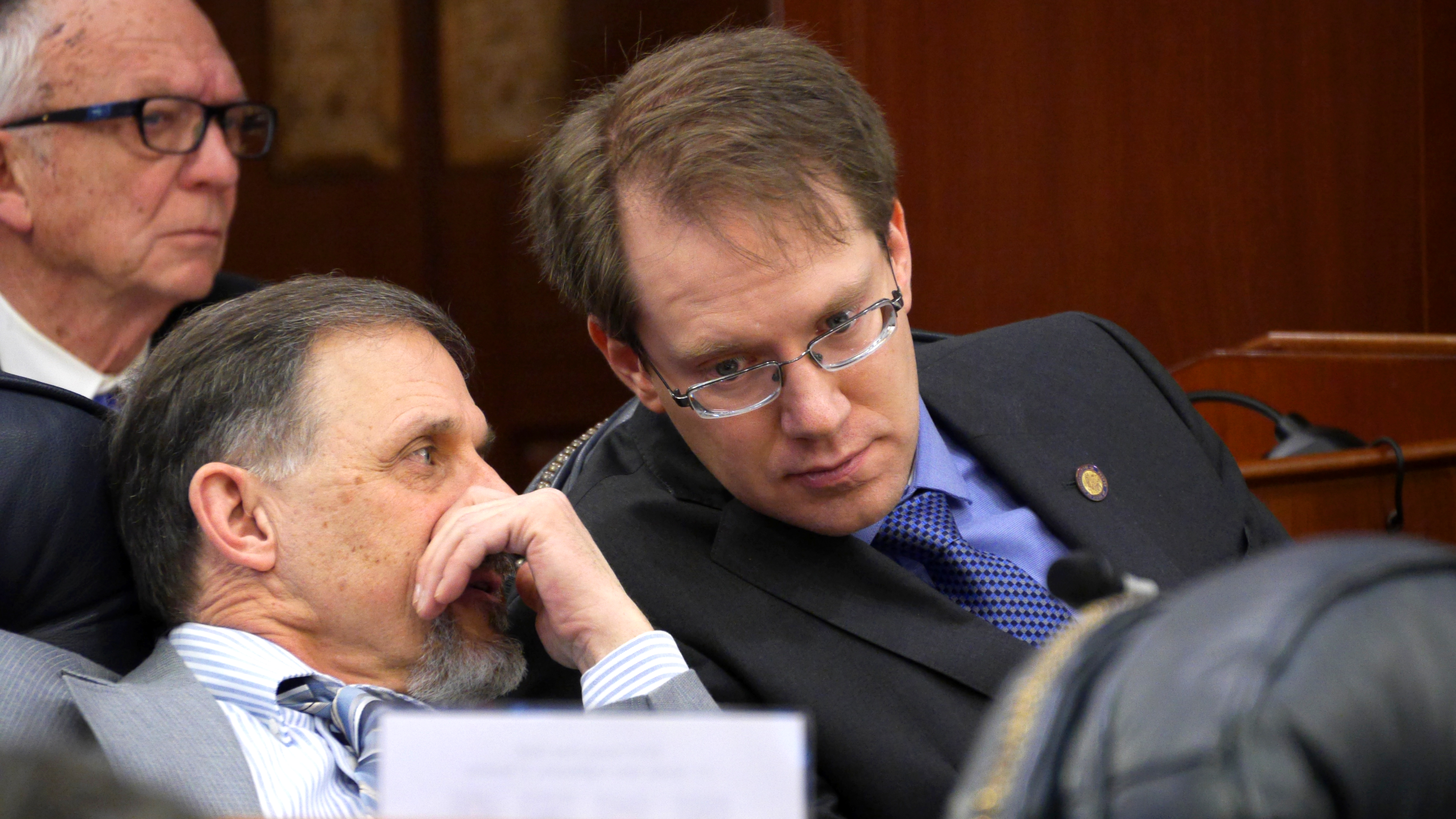 Rep. George Rauscher, R-Sutton whispers to Rep. Lance Pruitt, R-Anchorage, during a House floor session in the Capitol in Juneau on Feb. 15, 2019.