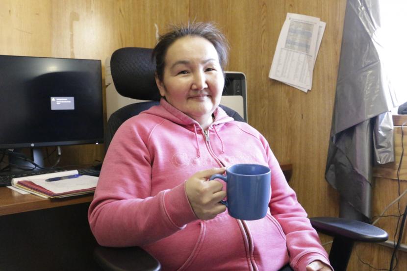 Eek Tribal Administrator and city council member Stella Alexie drinks coffee made with rain water in the Eek tribal/city office building. Many residents prefer to brew coffee and tea with rain water, saying it tastes better without chlorine on Feb. 21, 2019. (Photo by Anna Rose MacArthur/KYUK)