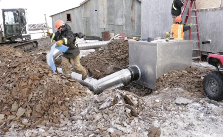 ANTHC workers install a water and sewer system to an Eek home on February 21, 2019. (Photo by Anna Rose MacArthur/KYUK)