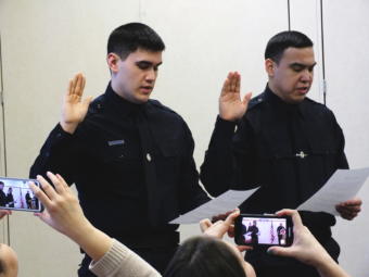 Family and friends record the swearing in of new Juneau Police Officers Jonah Hennings-Booth and Duain White during a ceremony at the Juneau Police Department on Feb. 21, 2019.