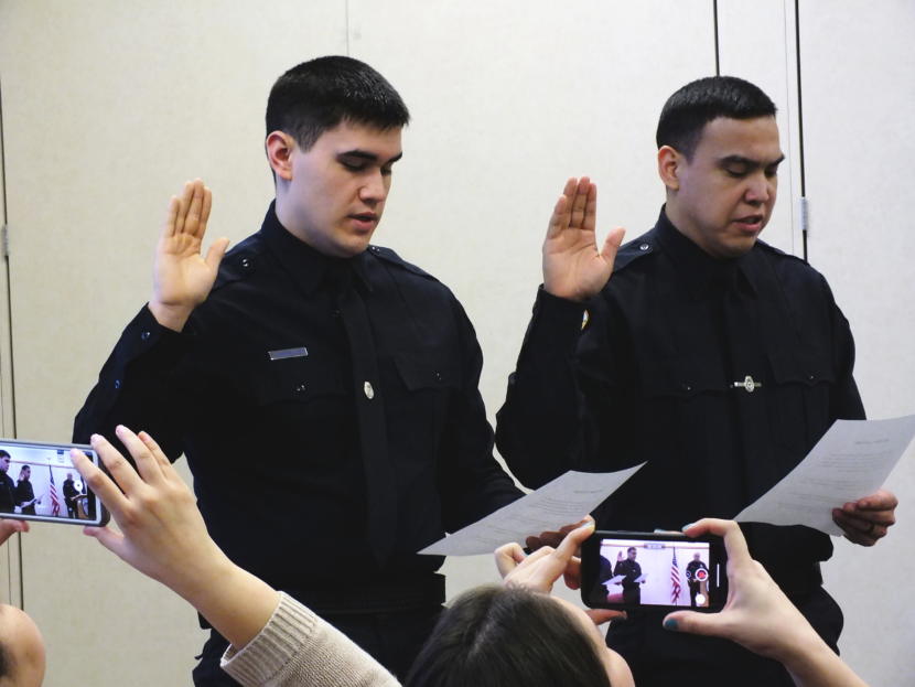 Family and friends record the swearing in of new Juneau Police Officers Jonah Hennings-Booth and Duain White during a ceremony at the Juneau Police Department Feb. 21, 2019.