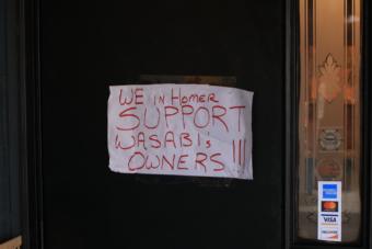 The same day racial slurs were spray-painted on the front of the restaurant, a sign from supporters was placed on the front door. (Photo by Aaron Bolton/KBBI)
