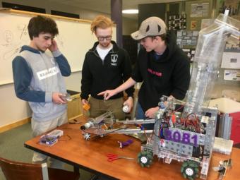 (From left) Eli Douglas, Noatak Post and Riley Sikes at a Thunder Mountain High School robotics practice on April 9, 2019. The trio has been building robots together since second grade. (Photo by Zoe Grueskin/KTOO)