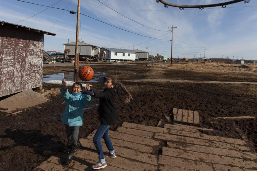 Megan Evan, 10, and Christine Aguchak, 9, play basketball after school on Wednesday, April 3, in Tuntutuliak, Alaska. (Photo by Rashah McChesney/Alaska's Energy Desk)