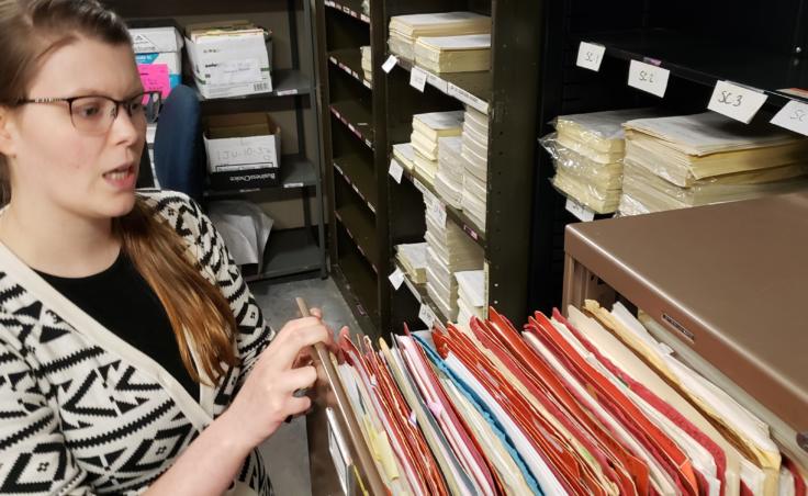 Records clerk Amanda Beebe-Bay flips through old case files stored in a basement storage room of the Dimond Courthouse in Juneau on April 22, 2019. This space is one of three areas in the courthouse used for file storage.