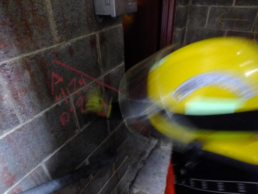 A firefighter uses chalk to mark out structural damage and number of victims in the next room during an urban search and rescue exercise in Juneau on April 12, 2019.