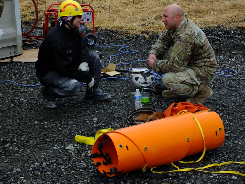 Meghan Desloover of Capital City/Fire Rescue chats with Tech Sgt. Derek Reese of Washington National Guard as he takes a break from jackhammer work during an urban search and rescue exercise in Juneau on April 12, 2019.