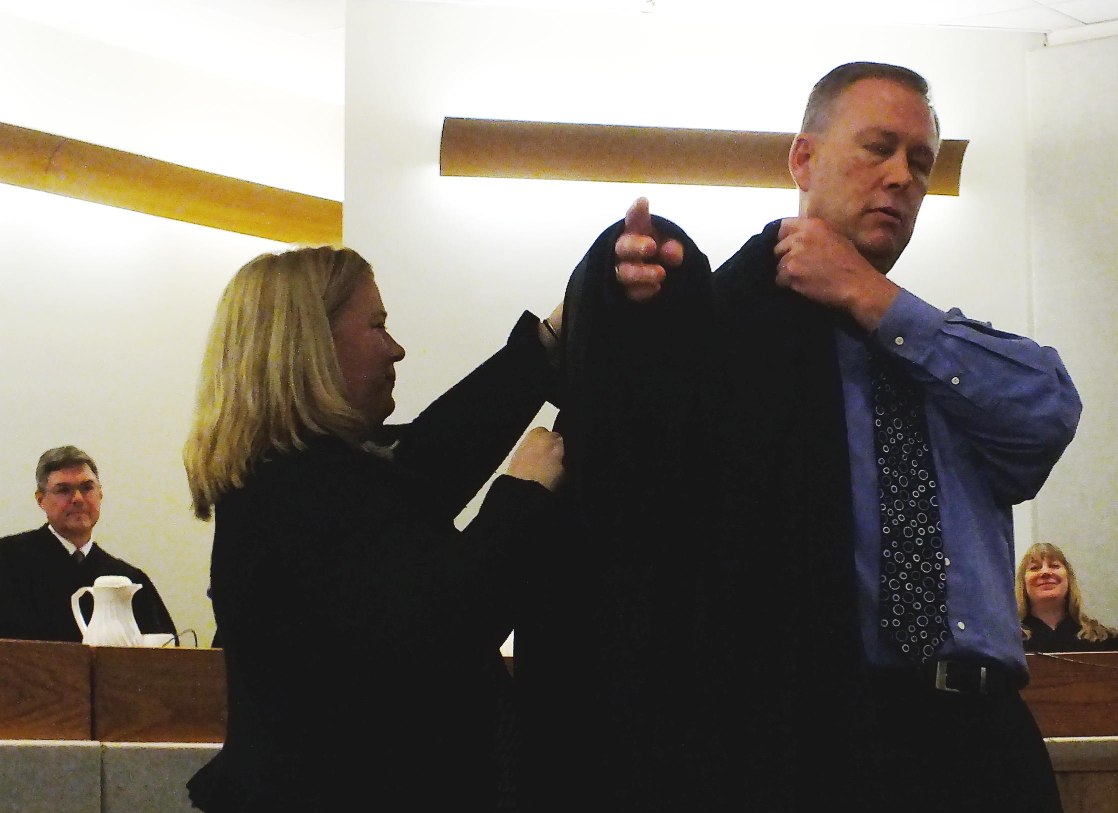 Juneau Superior Court Judge Daniel Schally dons the judicial robe with the help of his cousin Catherine O'Connor who traveled from Ireland to attend his installation ceremony March 29, 2019 at the Dimond Courthouse. (Photo by Matt Miller/KTOO)