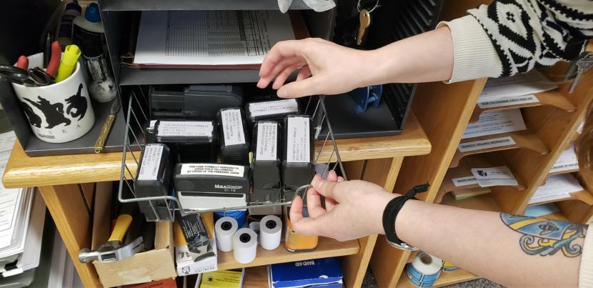 Records clerk Amanda Beebe-Bay pulls a stamp to mark a small claims complaint with the judge assigned to the case in the Dimond Courthouse in Juneau on April 22, 2019. The court system's case management system CourtView assigns judges when clerks enter data from complaints.