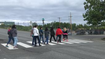Anchorage residents walk across Fourth Avenue during a tour led by Partners Reentry Center on May 24, 2019.