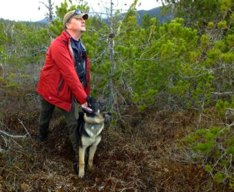 SEADOGS’ Liam Higgins holds on to Oskar, his 5 month old German Shepherd, while he looks to make sure that a volunteer is hidden before giving the command to “Find him!”. (Photo by Matt Miller/KTOO)