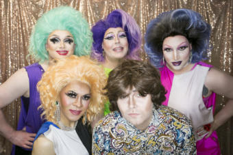 Drag performers stand in front of a gold background Juneau drag performers pose backstage at Centennial Hall for the 5th Annual GLITZ Drag Show and Juneau Pride Kickoff at Centennial Hall on Friday, June 14, 2019. Artists Lola Monèt, Shirley Wood, Miss Guise, Aura Borealis and Dear Evan Handsome took the stage for an opening number inspired by the 1969 Stonewall riots. (Photo by Annie Bartholomew/KTOO)