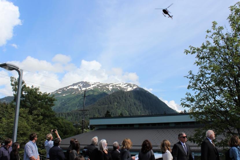 A helicopter flies over the memorial service for three air ambulance crew members who died when their plane went down in January. (Photo by Adelyn Baxter/KTOO)